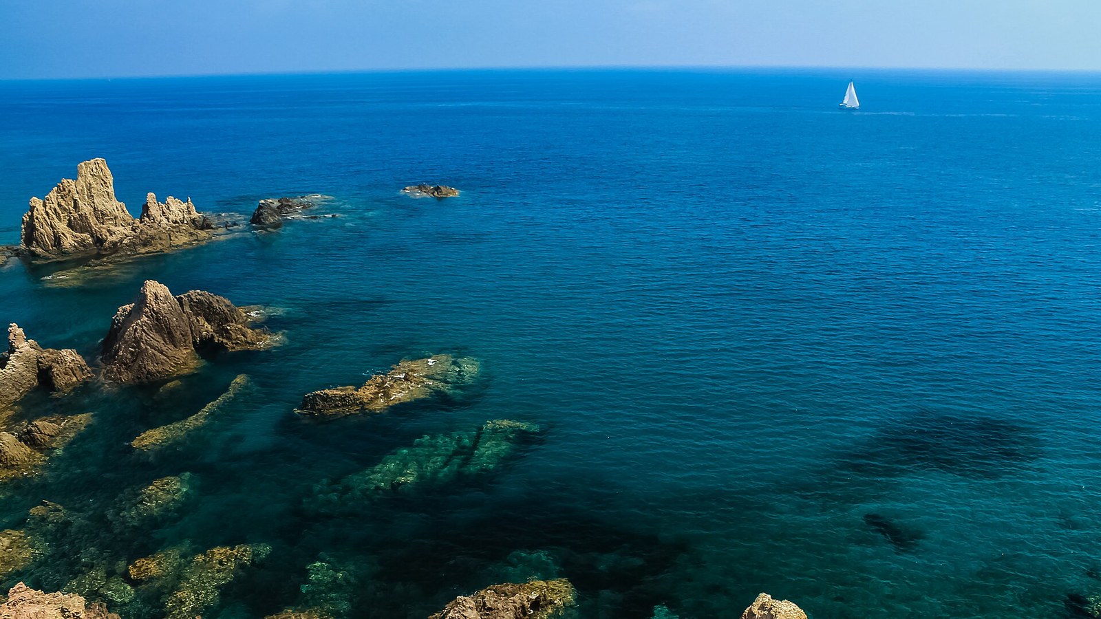 Agua turquesa y roca volcánica en el Arrecife de las Sirenas, en Cabo de Gata
