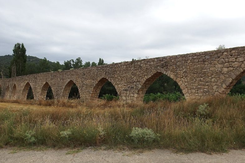 El acueducto de Los Arcos de Alpuente, con su larga hilera de arcos apuntados sobre los campos