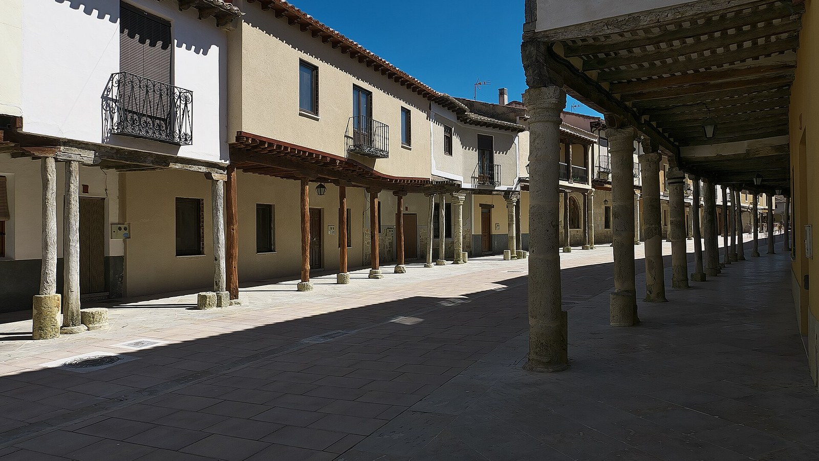 Calle porticada de Ampudia con columnas de madera sobre basas de piedra