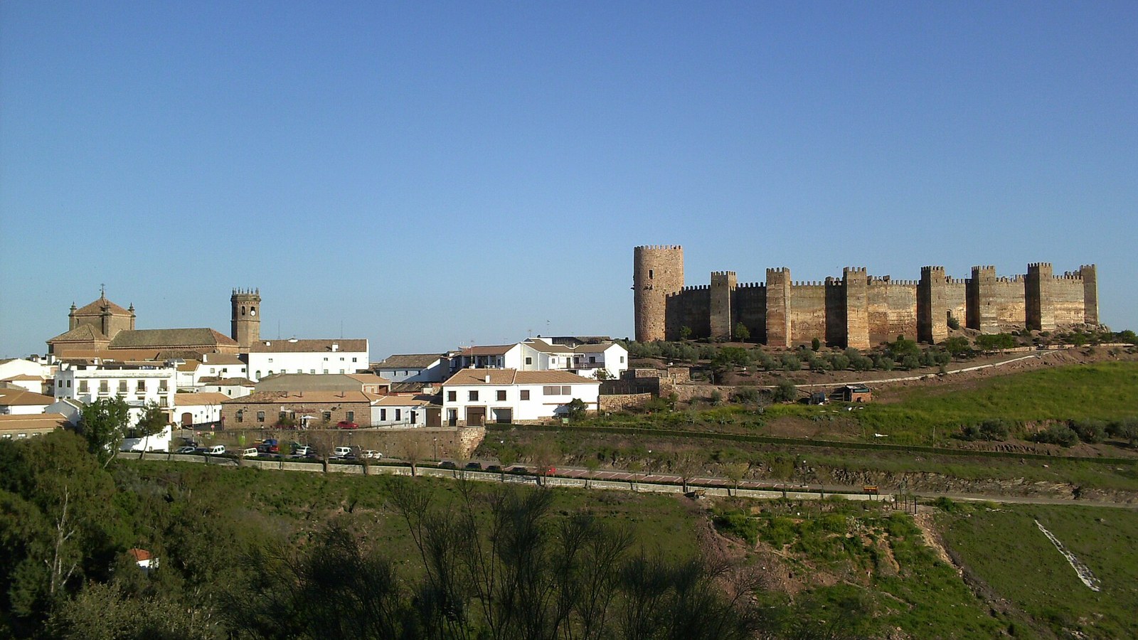 El castillo de Burgalimar con su muralla de torres sobre Banos de la Encina