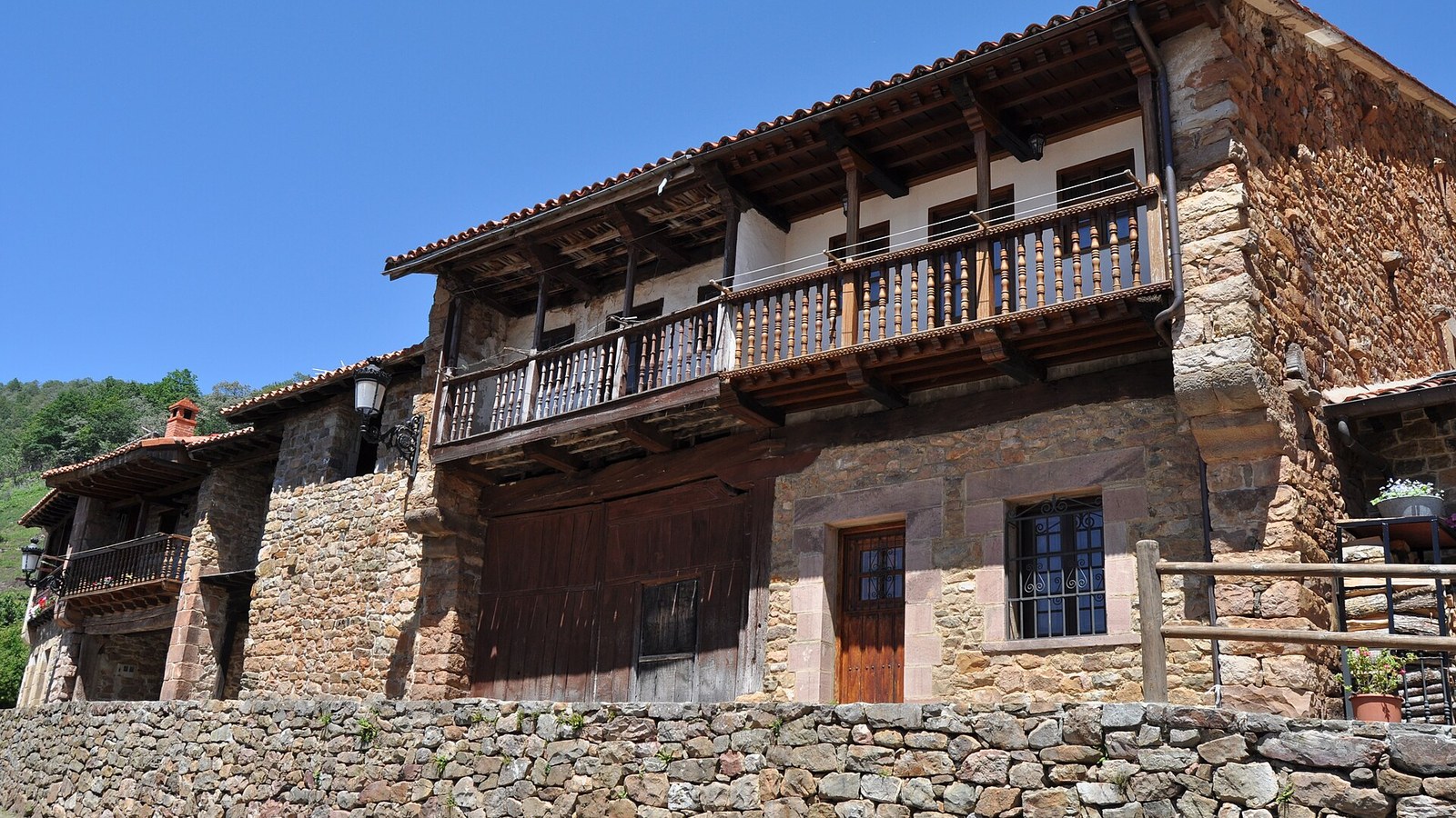 Casona montañesa de piedra con balcón corrido de madera en Bárcena Mayor