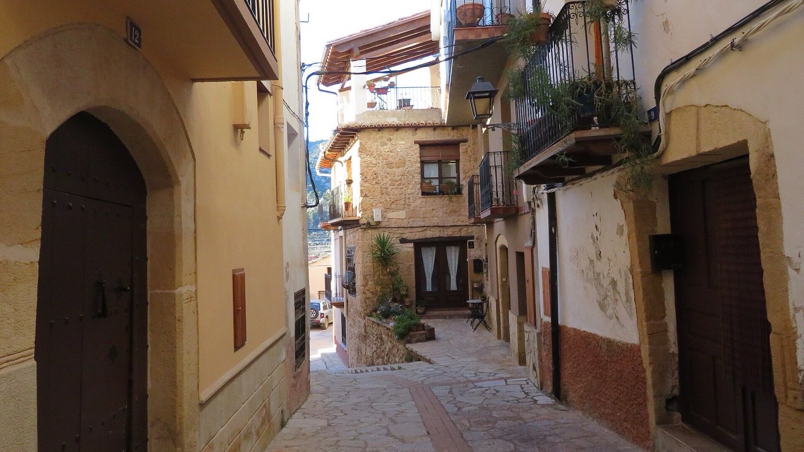 Calle empedrada del casco antiguo de Beceite con casas de sillería y balcones de forja