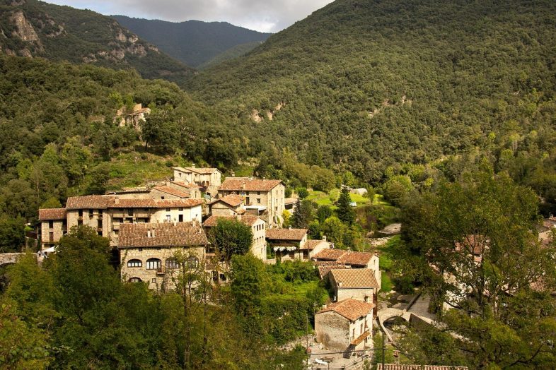 El pueblo de Beget entre bosques, con sus tejados de teja arabe en el fondo del valle