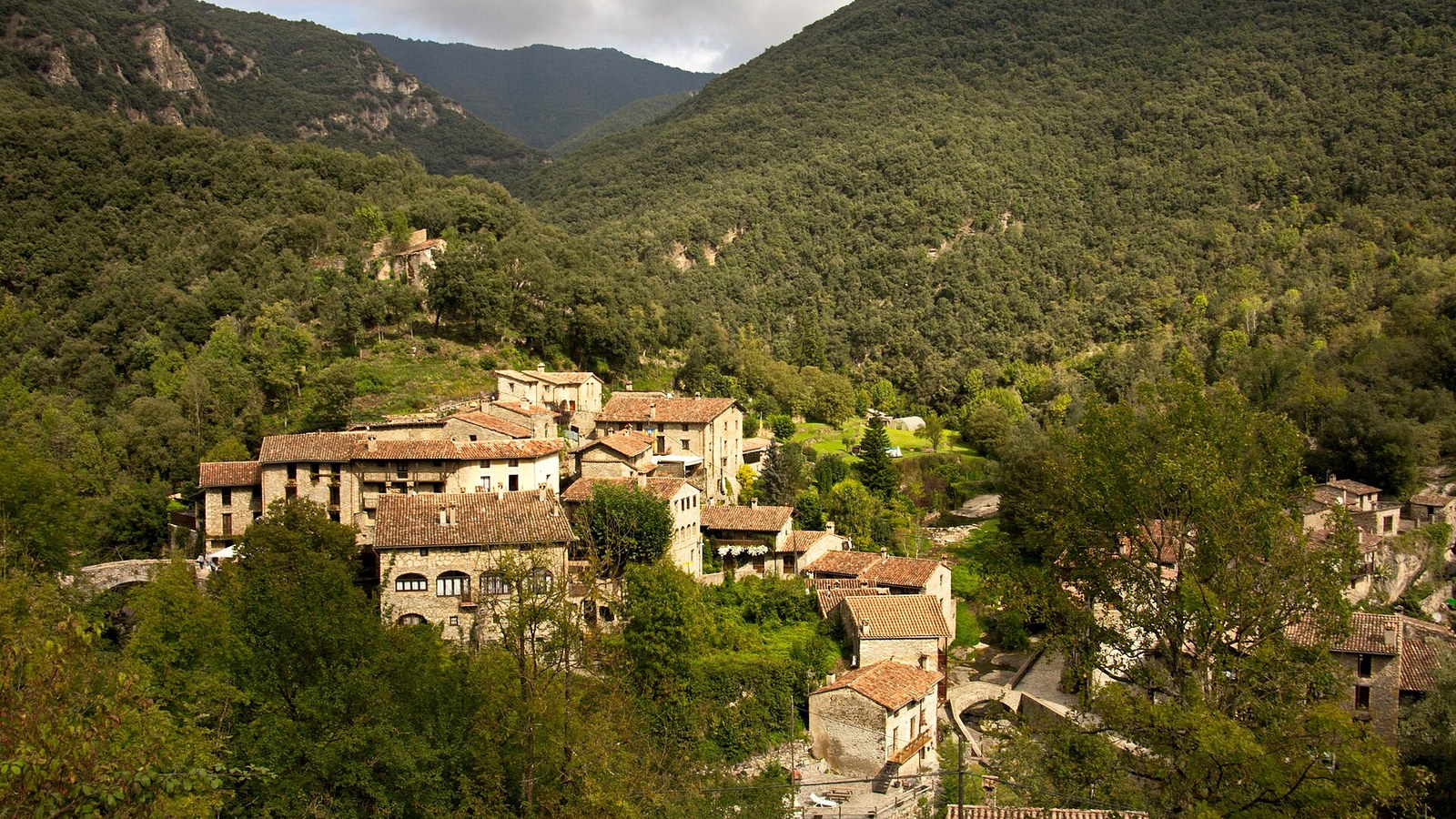 El pueblo de Beget entre bosques, con sus tejados de teja árabe en el fondo del valle