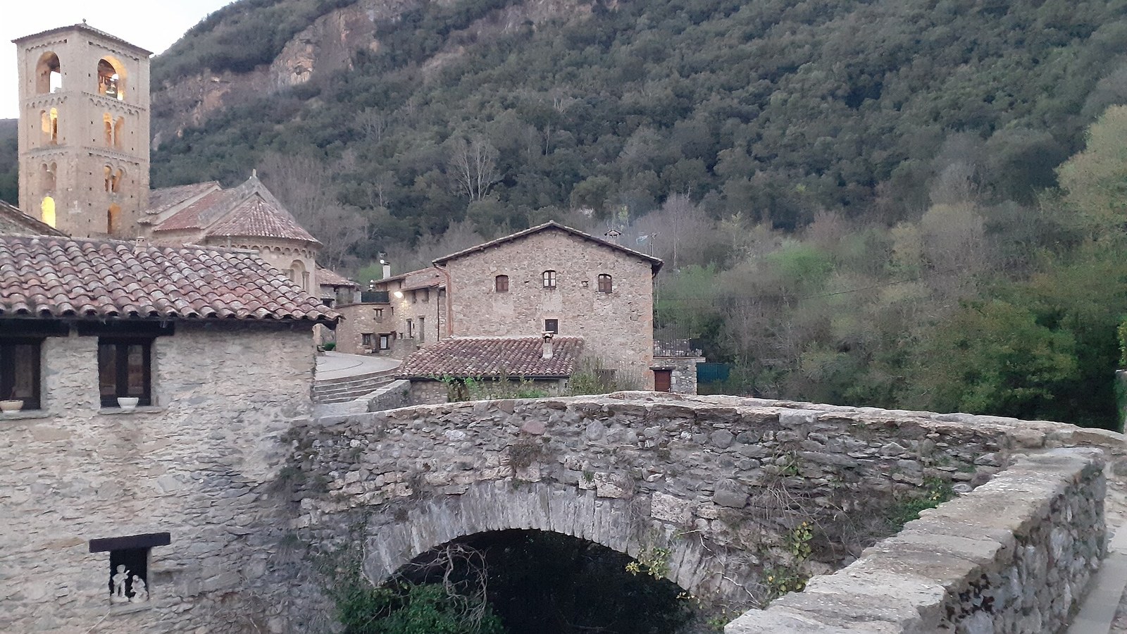 El puente medieval de Beget con el campanario románico de San Cristóbal al fondo