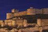 El castillo de Berlanga de Duero iluminado al anochecer sobre su cerro