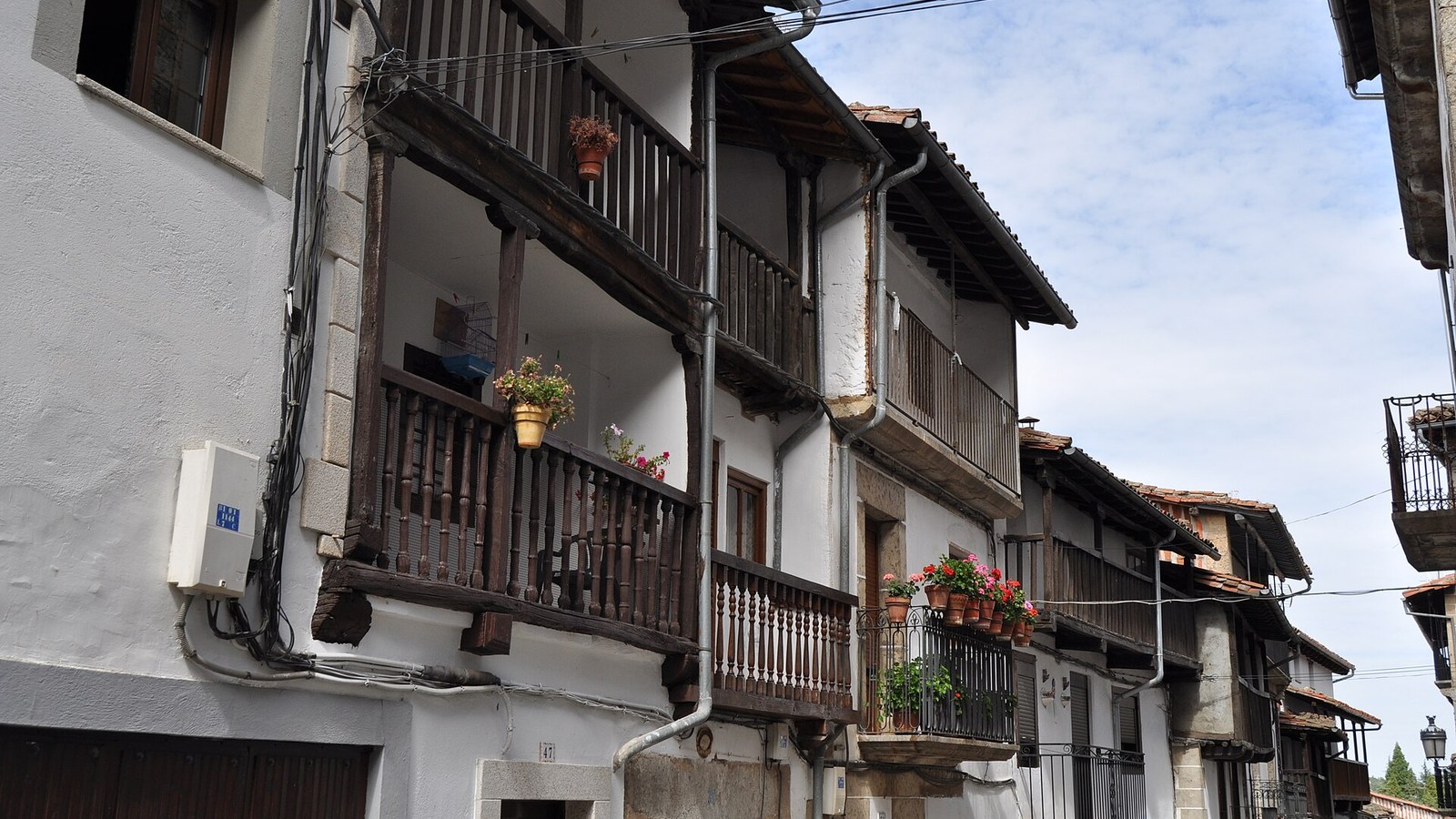 Calle de Candelario con las casas de balcones corridos de madera y macetas de geranios