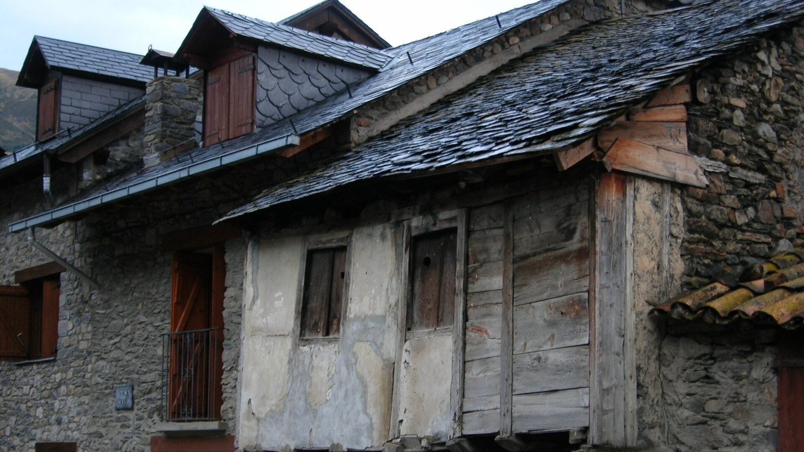 Casa tradicional de Durro con muros de piedra, galería de madera y tejado de pizarra