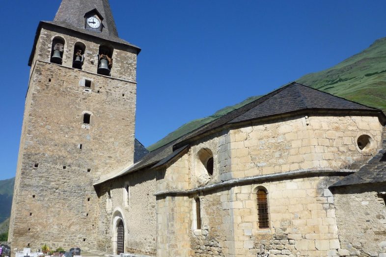La iglesia de San Julian de Garos con su campanario ancho y la montana detras