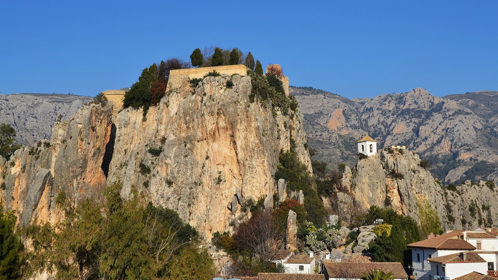 El peñón de Guadalest con los restos del castillo en lo alto y las casas blancas al pie