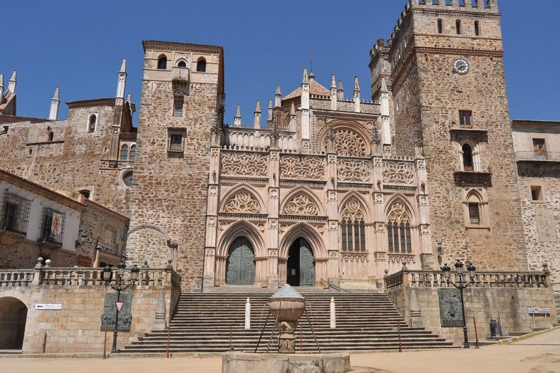 Fachada del Real Monasterio de Guadalupe con sus torres y la escalinata sobre la plaza