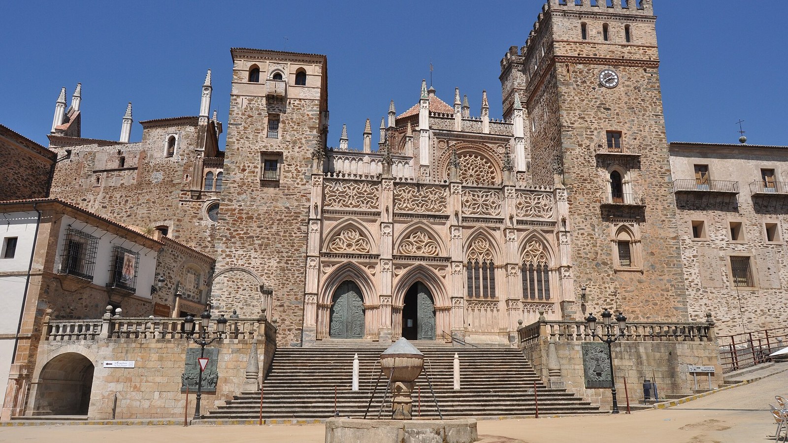 Fachada del Real Monasterio de Guadalupe con sus torres y la escalinata sobre la plaza