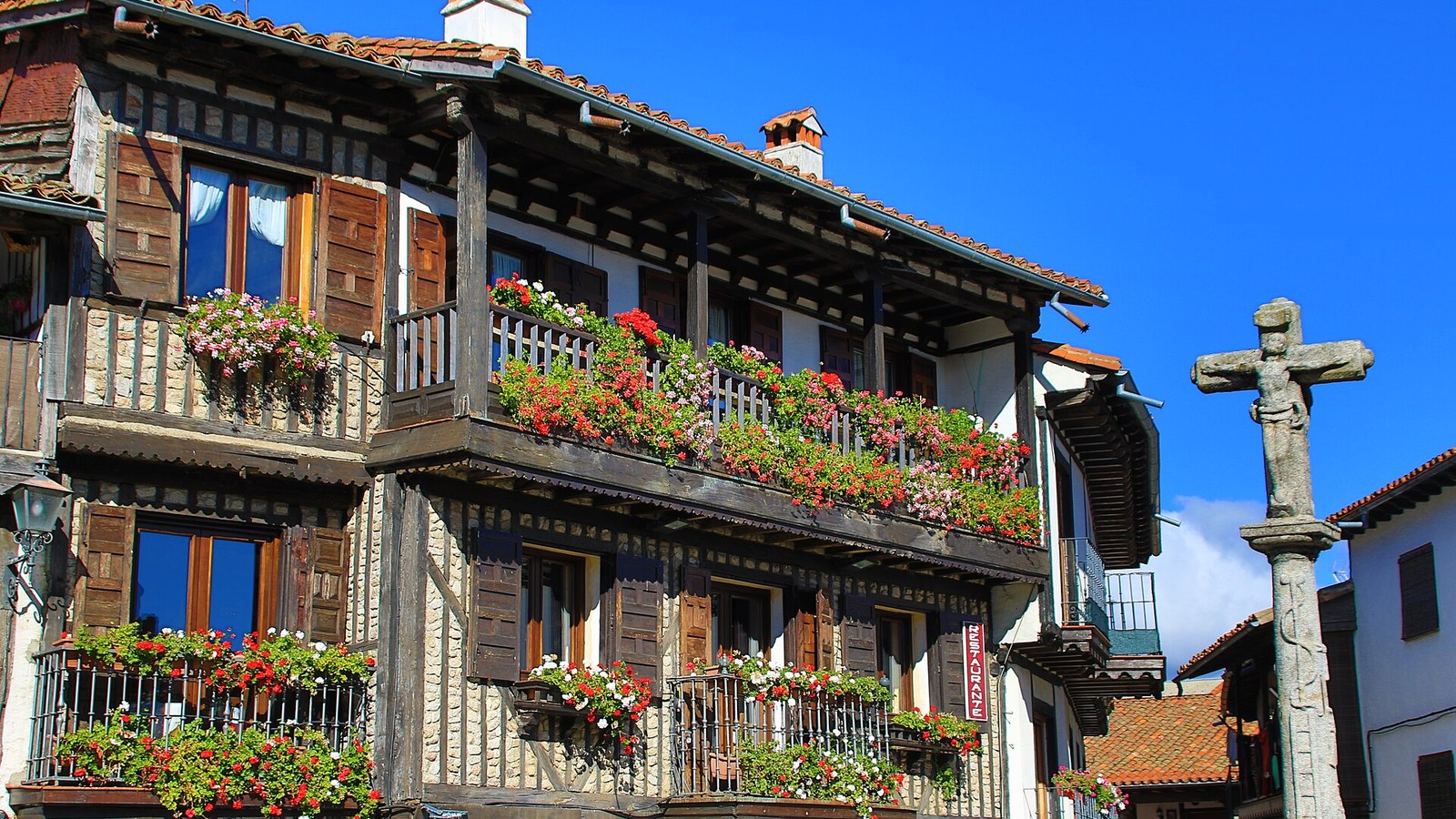 Balcones de madera con geranios en una casa tradicional de La Alberca