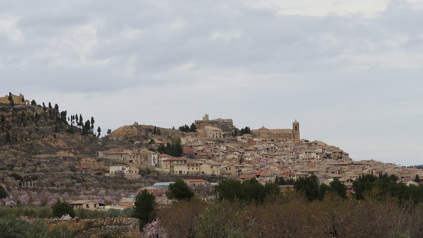 La Fresneda sobre su cerro, con la iglesia arriba y los olivos delante