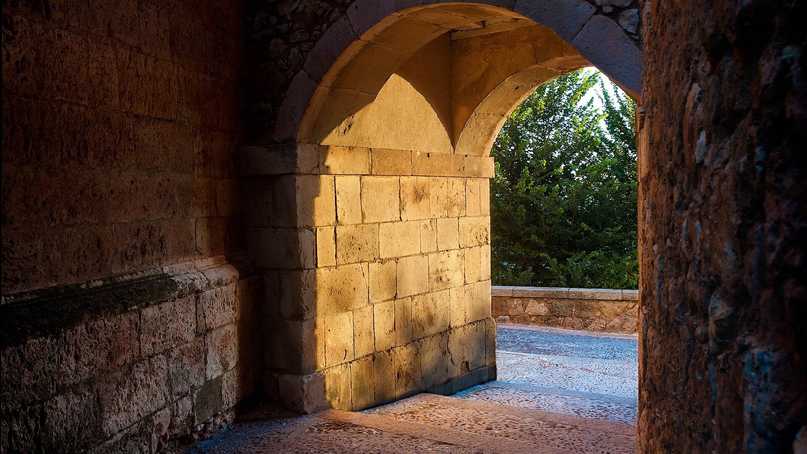 Arco de piedra de la muralla de Lerma con la luz entrando por el vano