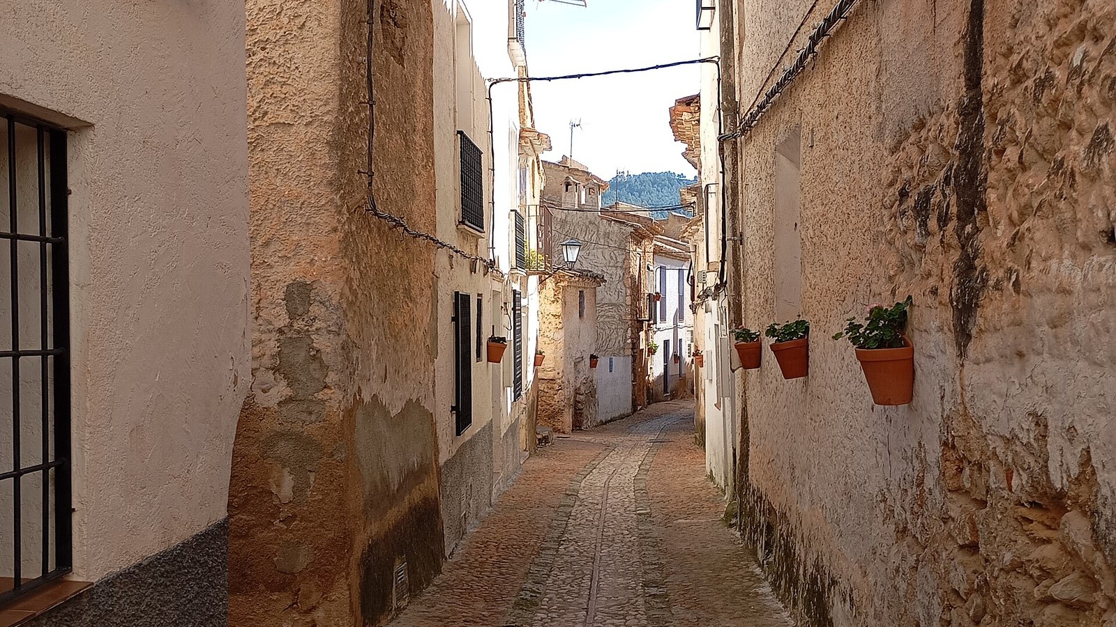 Callejón empedrado y estrecho entre casas encaladas en el casco histórico de Letur