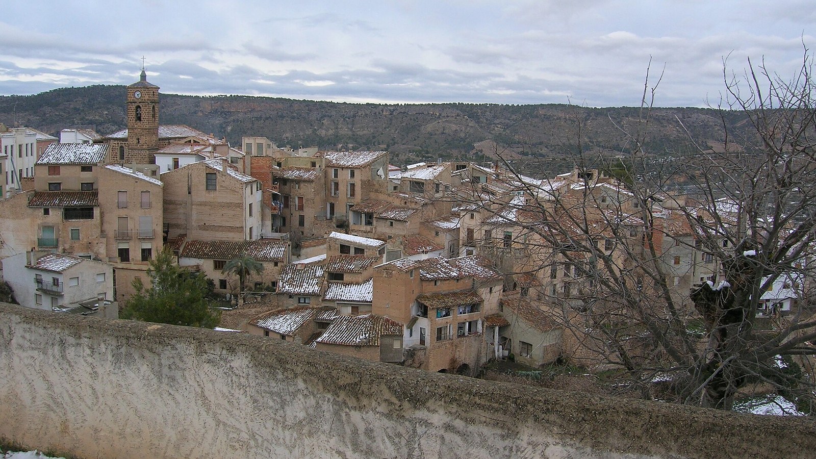 Letur sobre su cerro, con el caserío blanco y la sierra del Segura al fondo