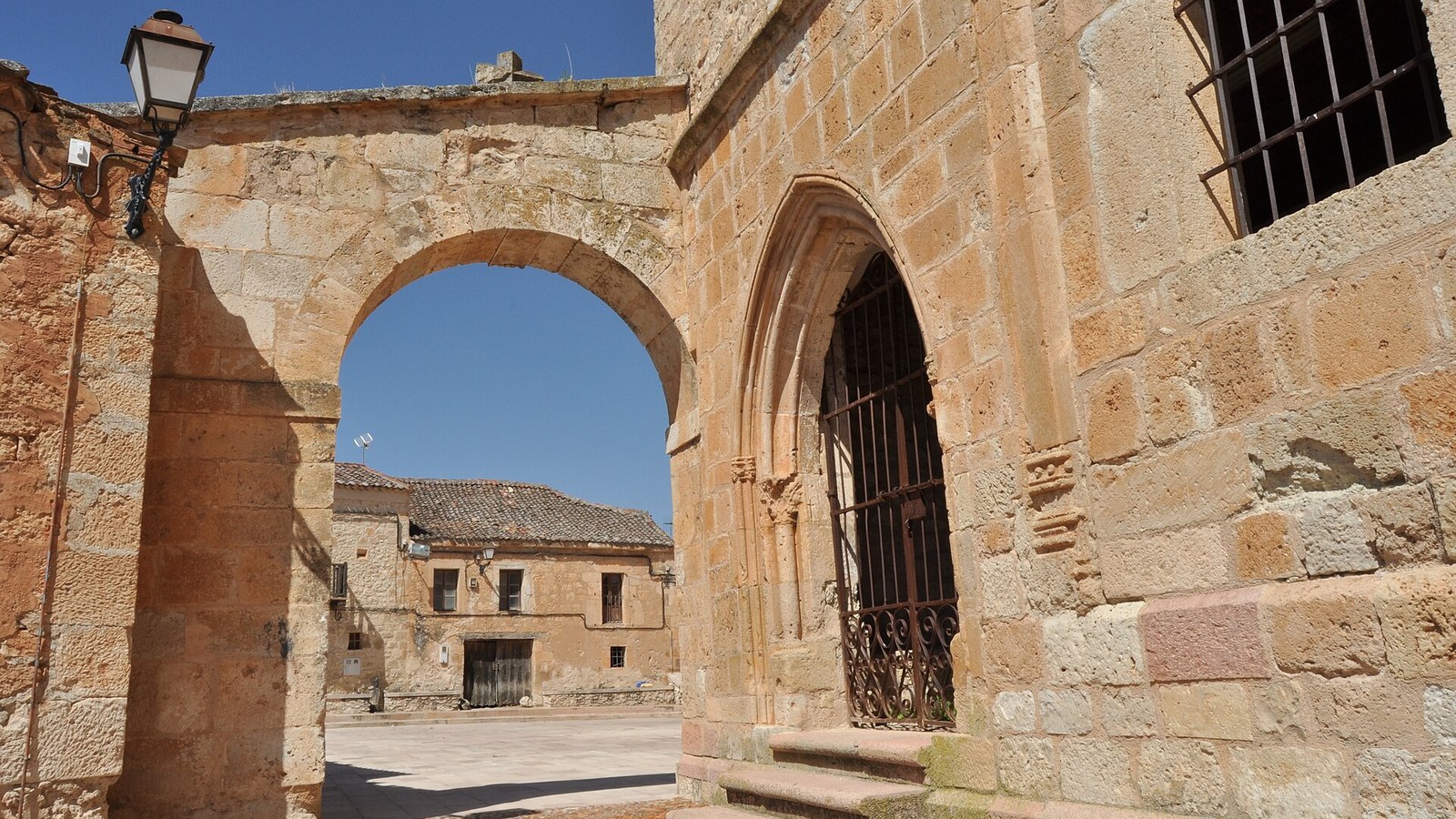 Arco de piedra y portada románica de la iglesia de Santa María en el casco de Maderuelo