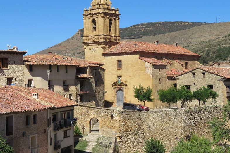 Mirambel completamente amurallado, con la torre de la iglesia y los montes del Maestrazgo detrás