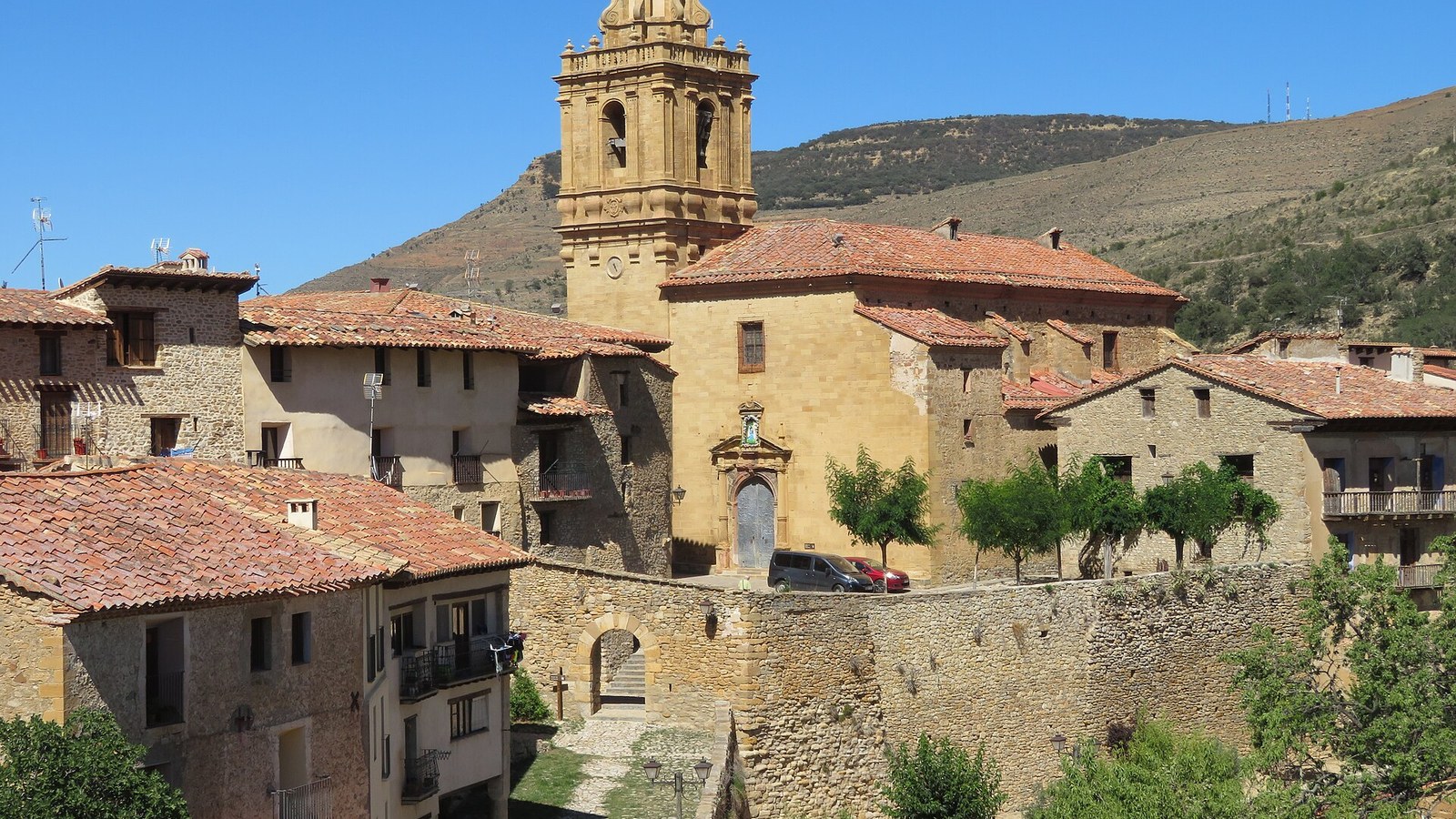 Mirambel completamente amurallado, con la torre de la iglesia y los montes del Maestrazgo detrás