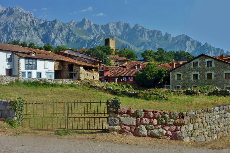 Mogrovejo con su torre medieval y las casonas de piedra, con los Picos de Europa detrás