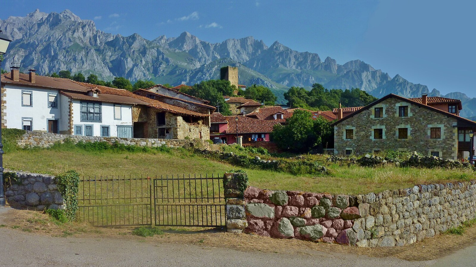 Mogrovejo con su torre medieval y las casonas de piedra, con los Picos de Europa detrás