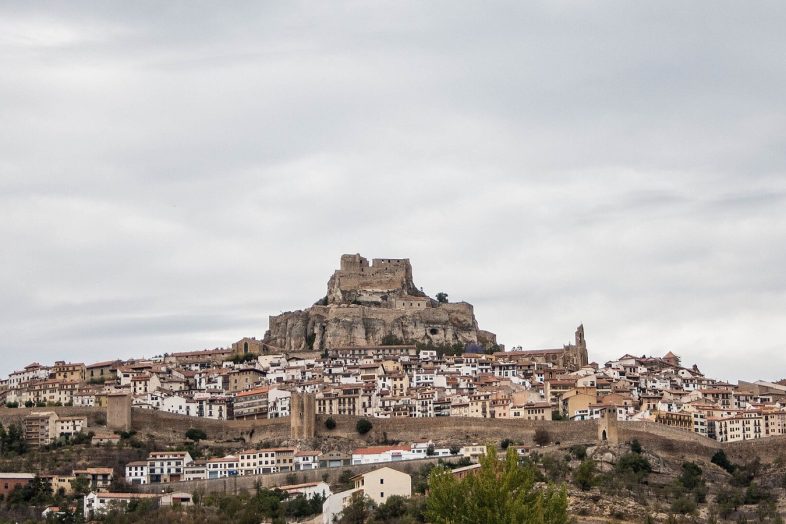 Morella amurallada sobre su muela, con el castillo en lo más alto y el caserío en la ladera