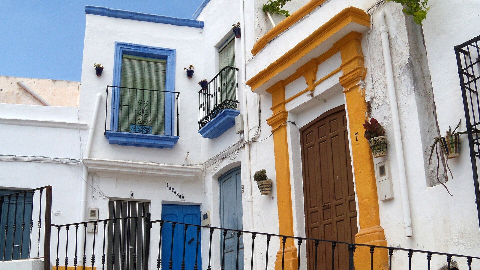 Casas de Níjar con portada amarilla, rejas y balcones pintados de azul