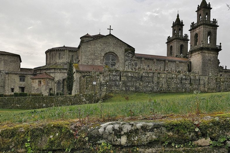 El monasterio de Santa Maria la Real de Oseira, con su iglesia y sus torres, entre prados
