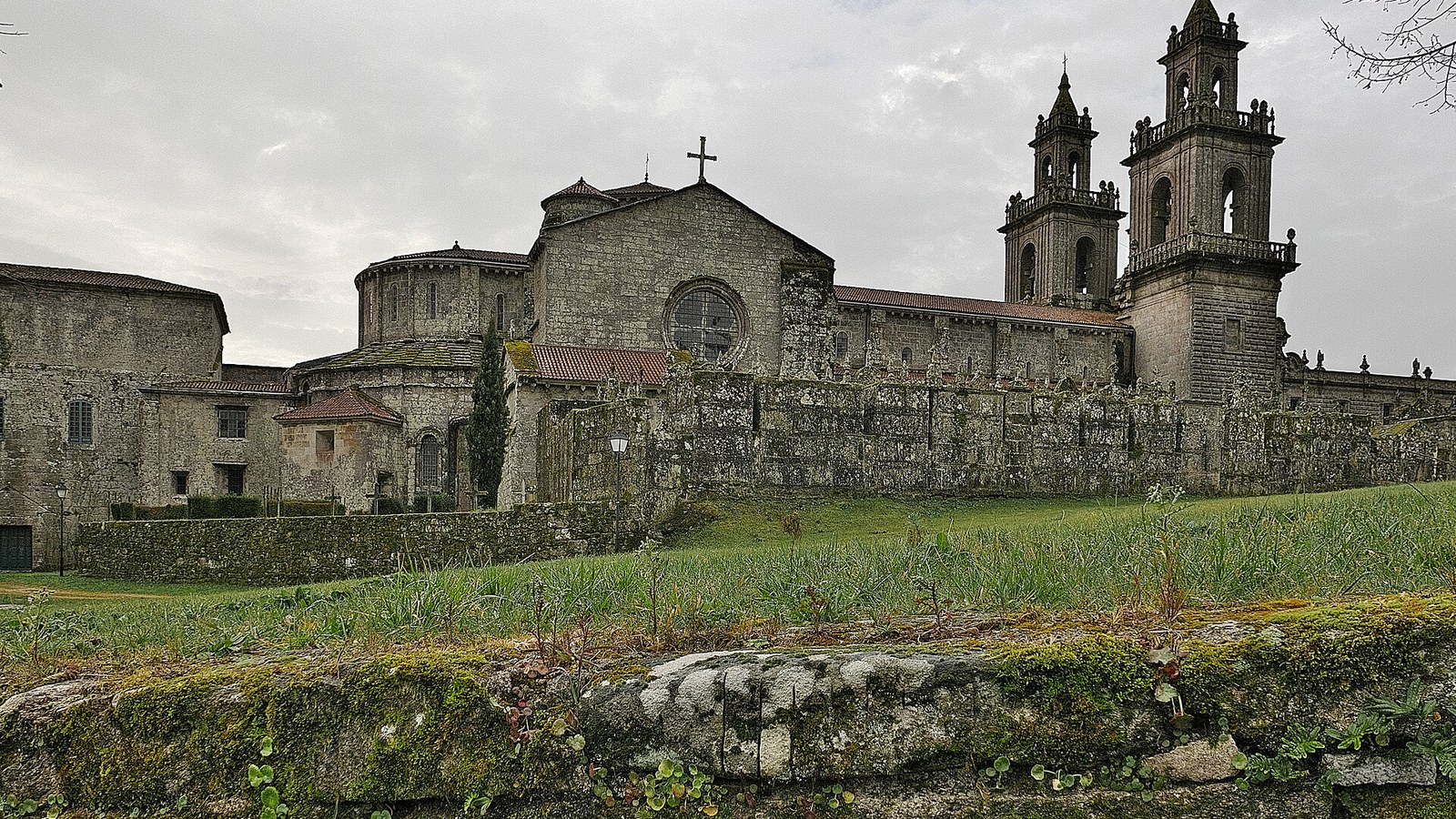 El monasterio de Santa Maria la Real de Oseira, con su iglesia y sus torres, entre prados
