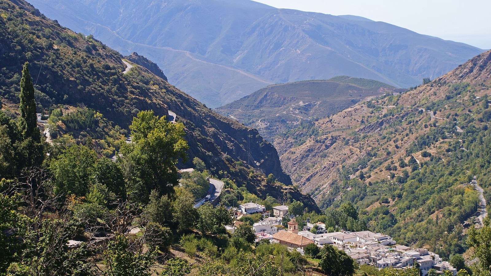 Pampaneira, pequeña y blanca, al fondo del enorme barranco de Poqueira en la Alpujarra