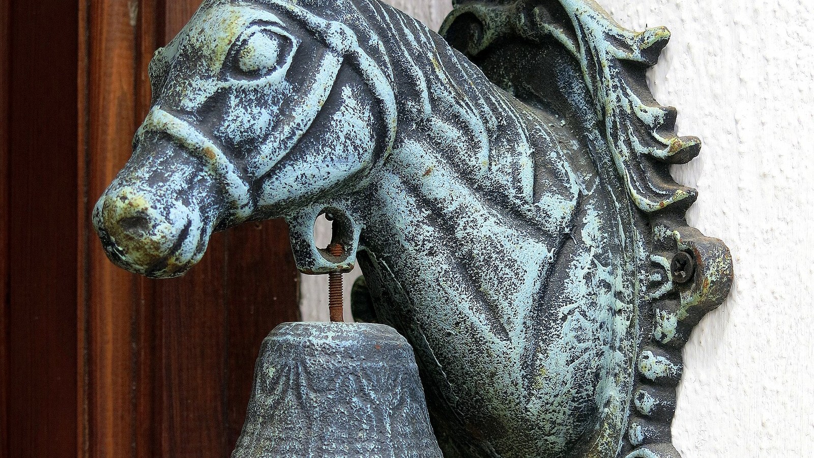 Aldaba de bronce con forma de cabeza de caballo en una puerta de Parauta