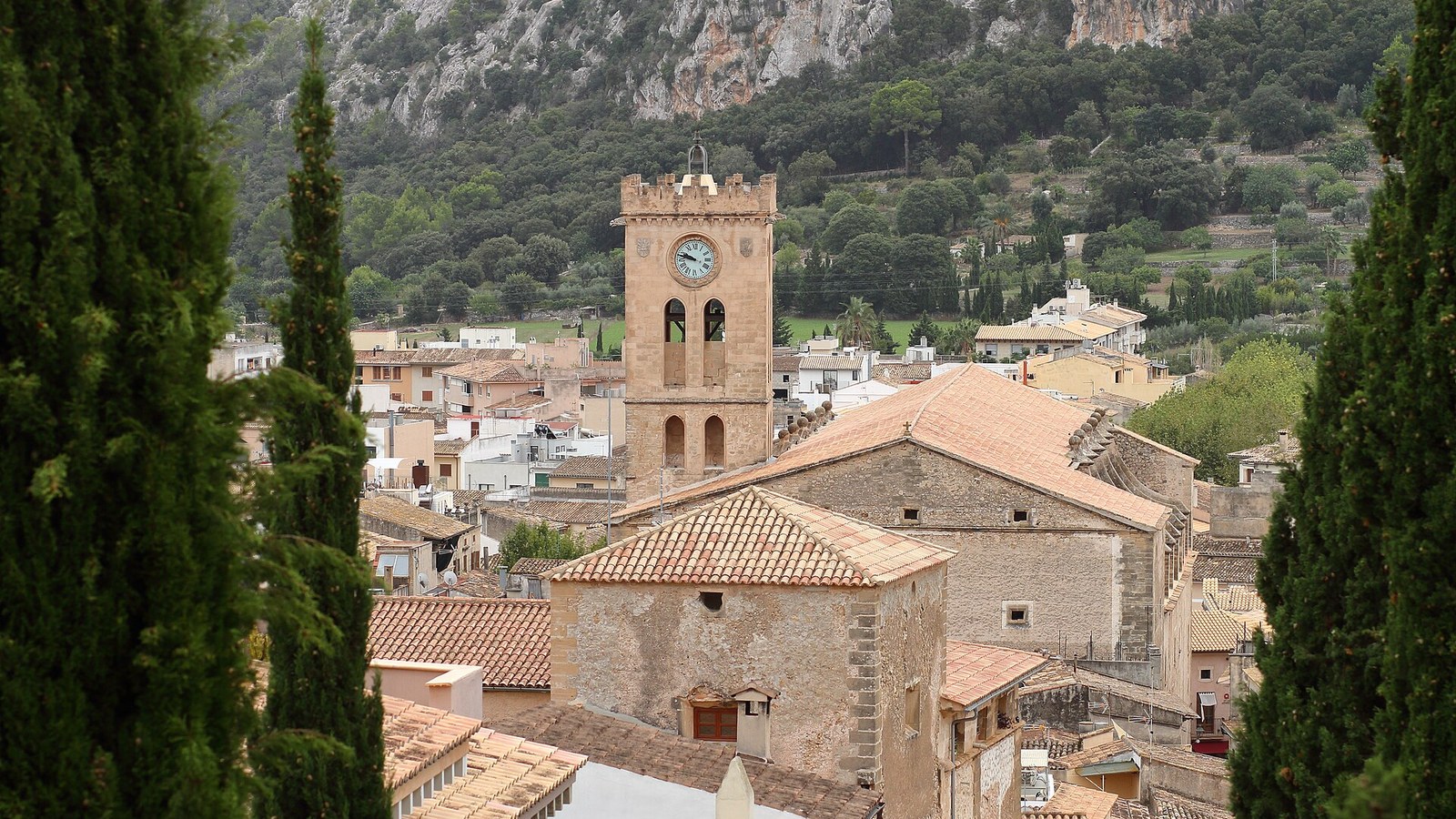 Los tejados de Pollensa y la torre del campanario entre cipreses