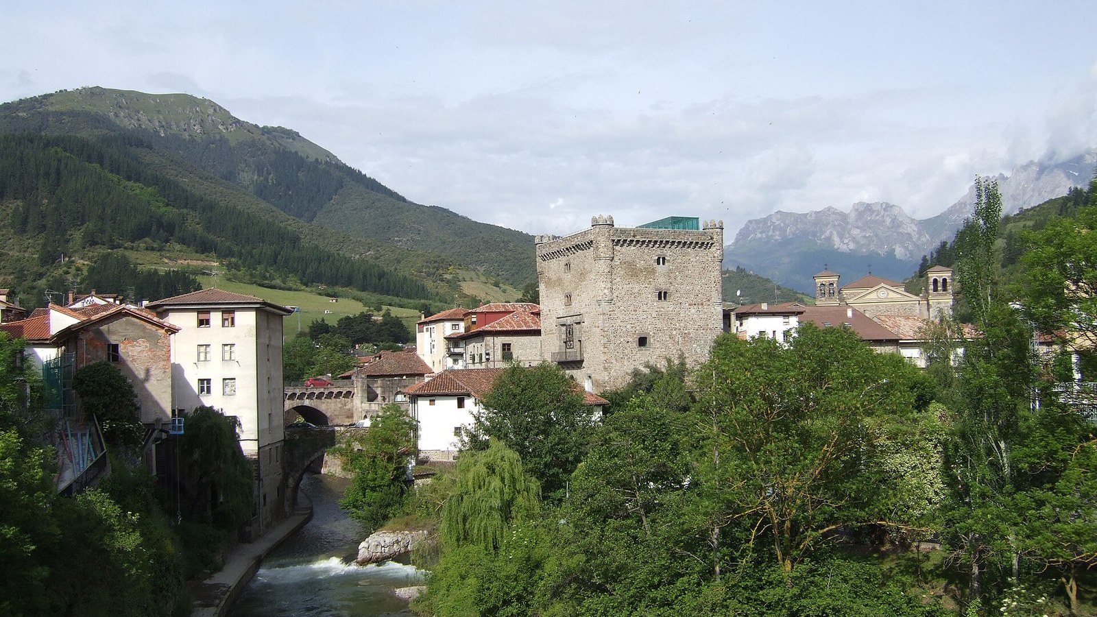 La Torre del Infantado de Potes sobre el río, con los Picos de Europa al fondo