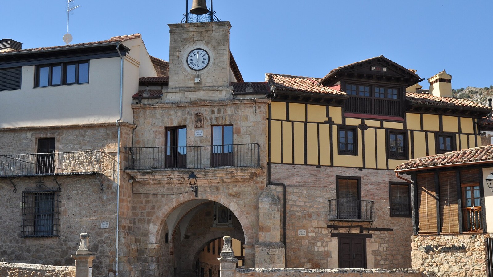 Puerta de acceso al casco amurallado de Poza de la Sal con el reloj y la campana encima