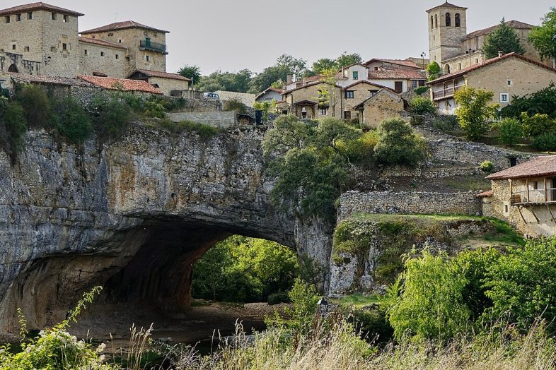 El puente natural de roca de Puentedey con el pueblo encima y el rio Nela por debajo