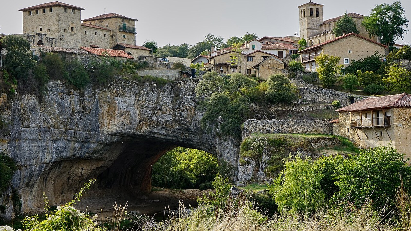 El puente natural de roca de Puentedey con el pueblo encima y el río Nela por debajo