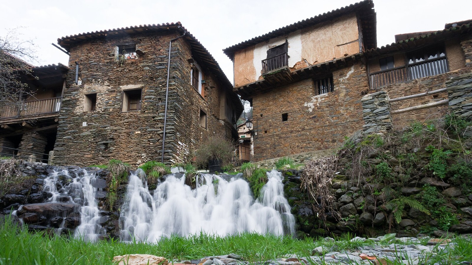 Casas de pizarra y adobe de Robledillo de Gata sobre la cascada del río