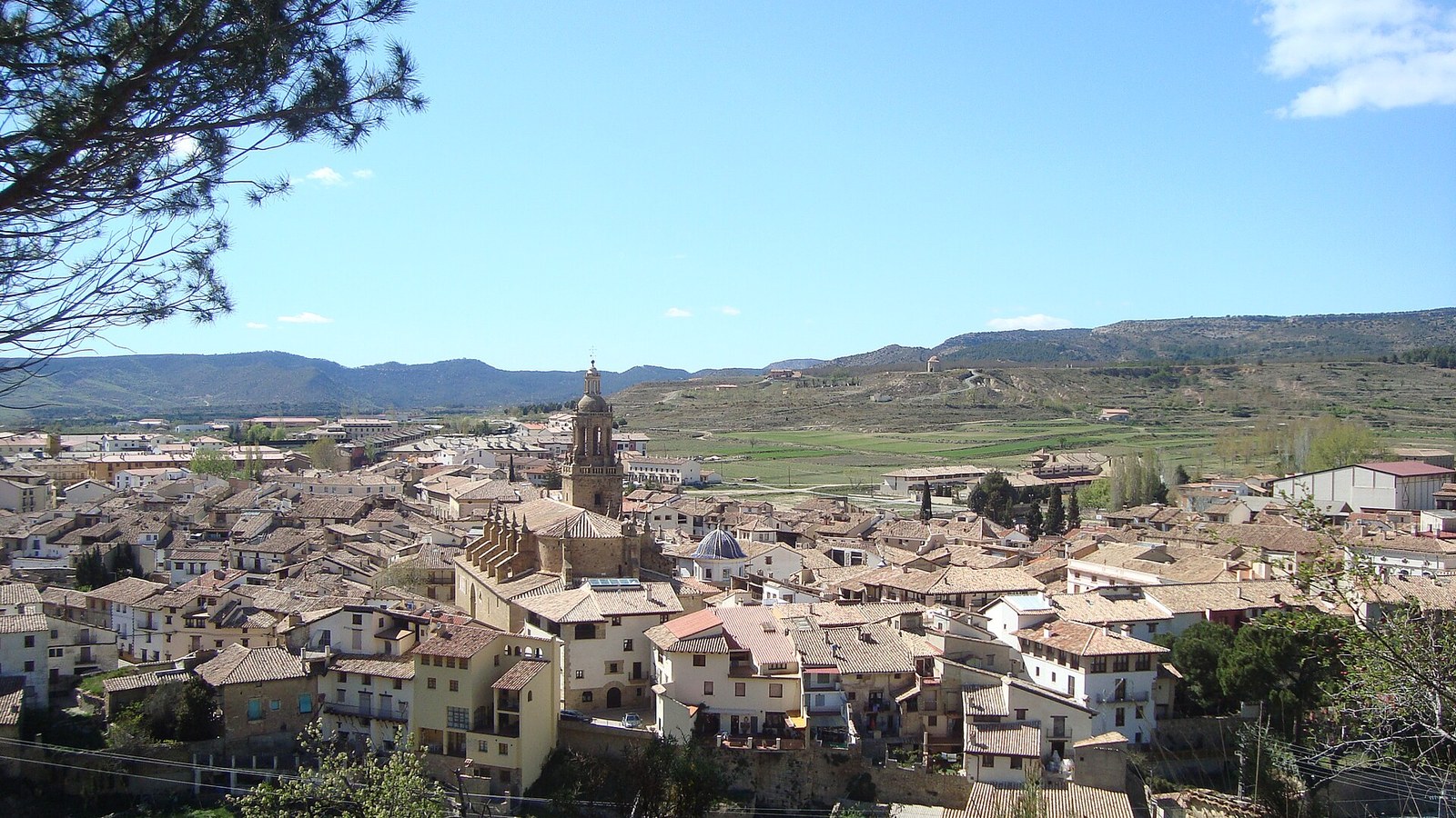 Panorámica de Rubielos de Mora con la torre de la iglesia sobre los tejados y la sierra de Gúdar