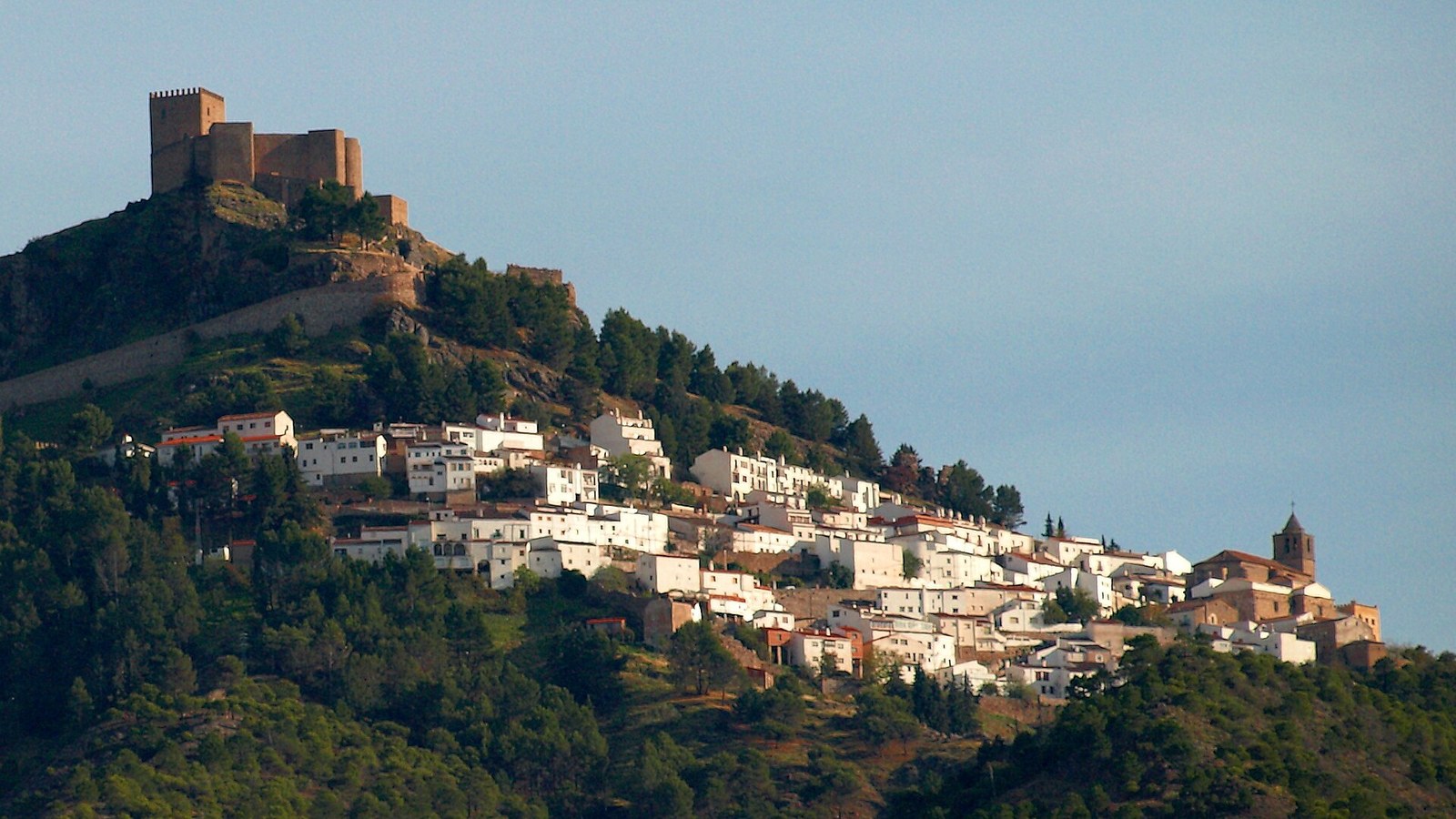 Segura de la Sierra escalonada bajo su castillo, en lo alto del cerro, rodeada de olivares