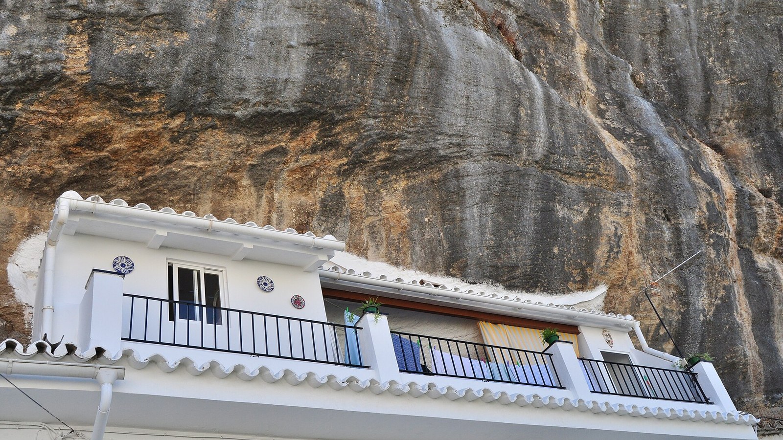 Casa encalada con la pared de roca del tajo formando el techo en Setenil de las Bodegas