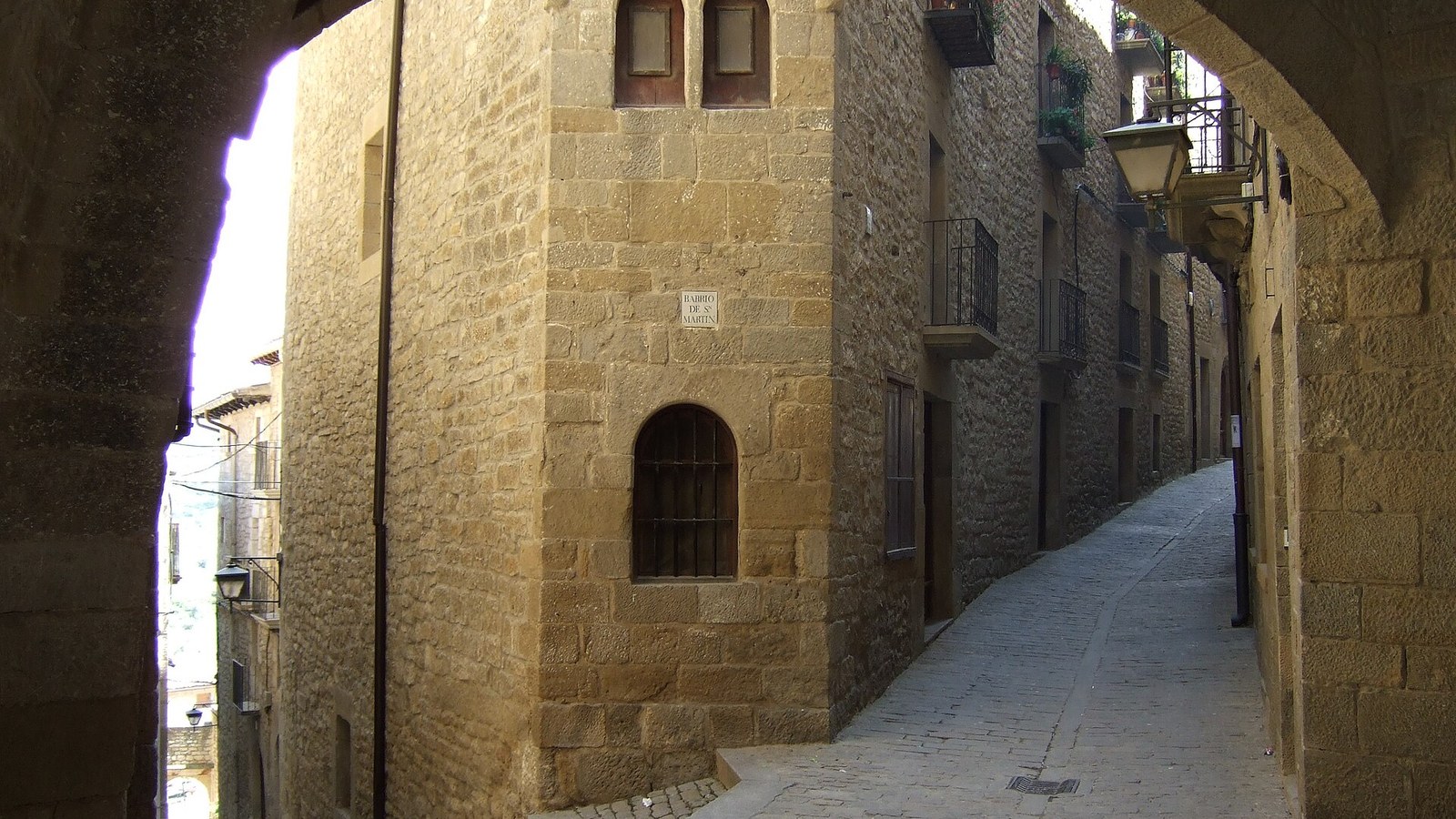 Calle empedrada de Sos del Rey Católico pasando bajo un arco de piedra