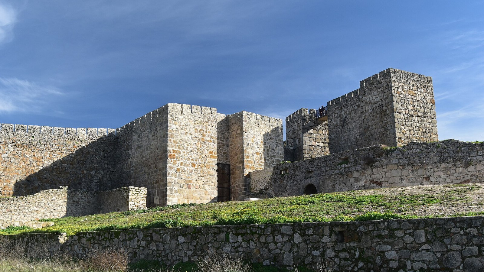 Lienzo de muralla y torres almenadas de la alcazaba de Trujillo sobre la ladera