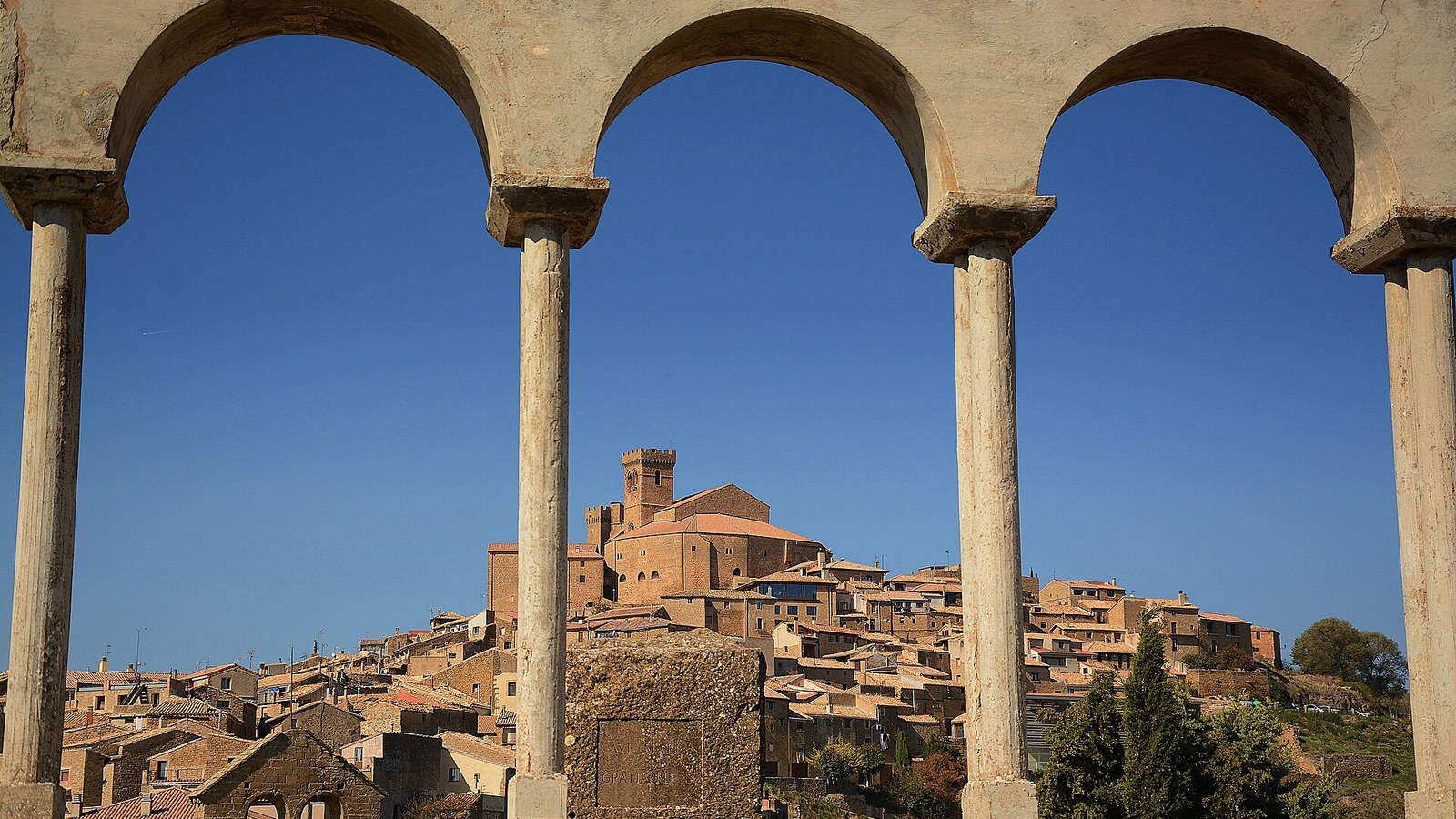 El caserío de Ujué visto entre los arcos del pórtico de Santa María