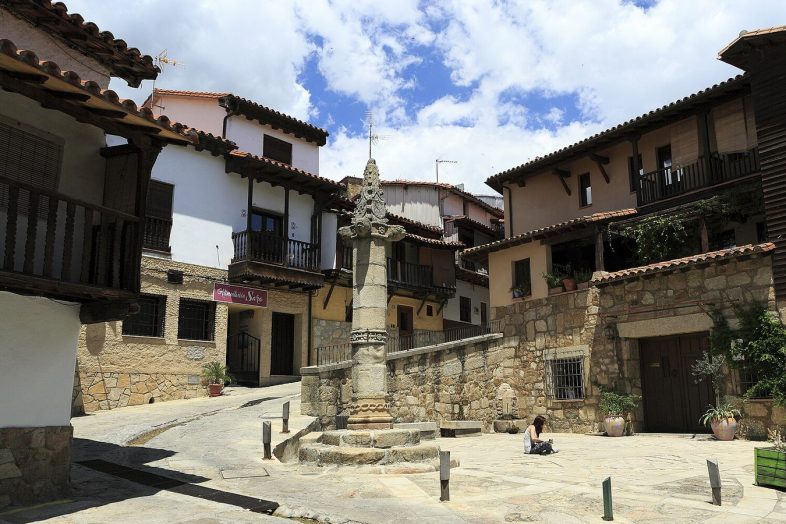 La picota gótica de Valverde de la Vera en su plaza, rodeada de casas con balconadas de madera