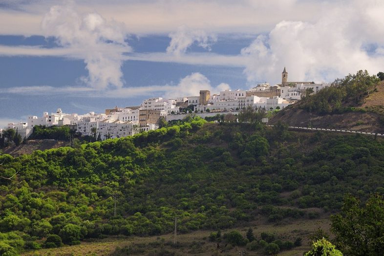 Vejer de la Frontera, blanco sobre su cerro verde, con grandes nubes atlánticas al fondo