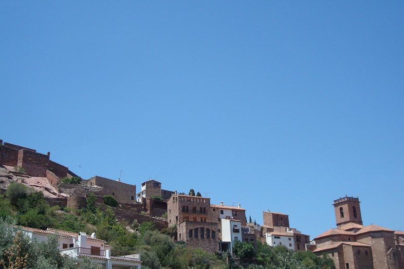 Vilafamés con sus casas blancas subiendo hacia el castillo de piedra roja en lo alto