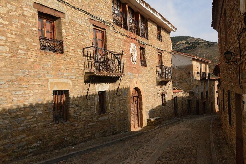 Calle de Yanguas con las casas de piedra ocre, balcones de forja y escudos labrados