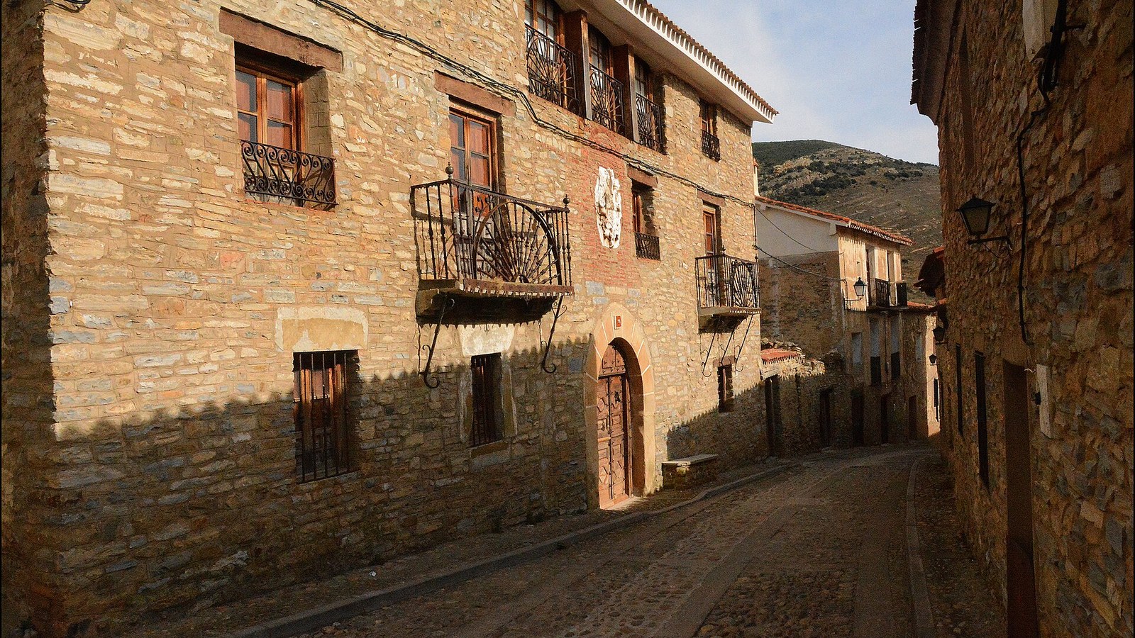Calle de Yanguas con las casas de piedra ocre, balcones de forja y escudos labrados
