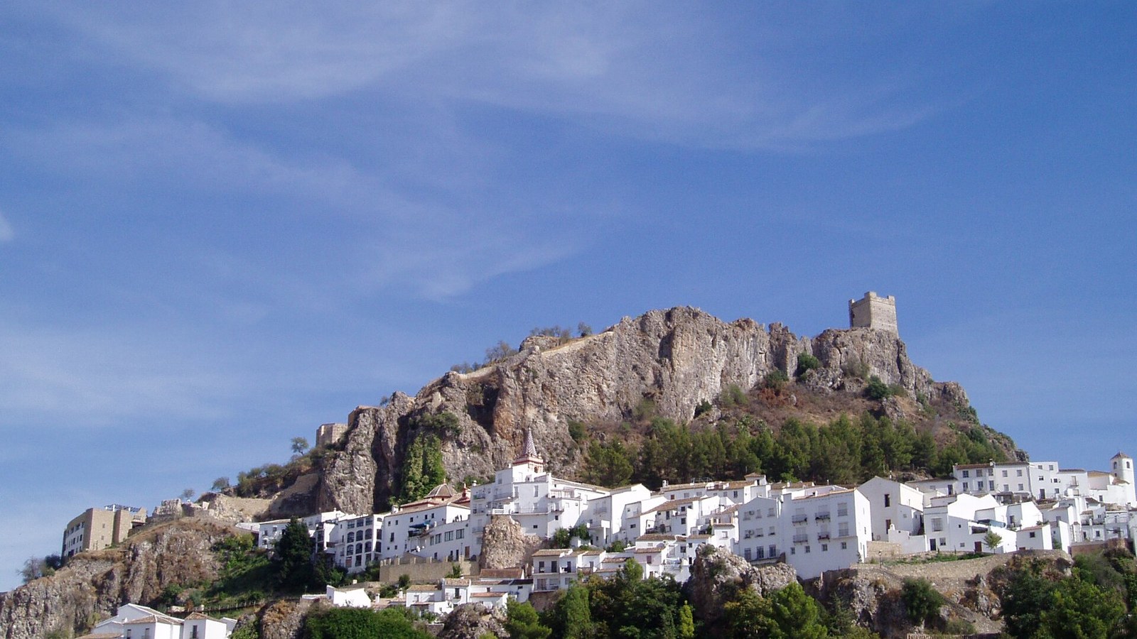 El peñón de Zahara de la Sierra con la torre del homenaje en lo alto y el caserío blanco debajo